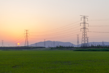 Sunset, electrical towers, wires, nergy Distribution Network - Electricity Pylons against Orange and Yellow Sunsetの写真素材