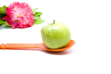 Green Apple on Orange Spoonの写真素材