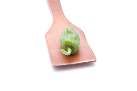 Green Capsicum on wooden spoonの写真素材