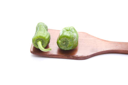 Green Capsicum on wooden spoonの写真素材