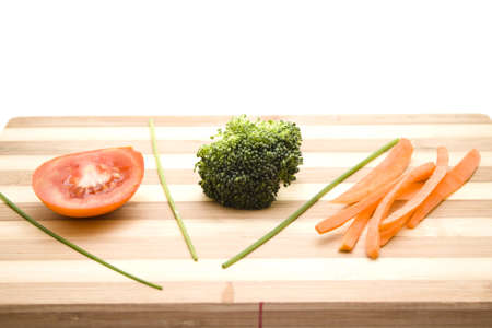 Tomato with Broccoli and Carrots on Wooden Plateの写真素材