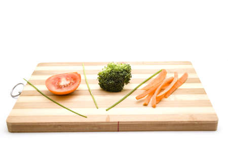 Tomato with Broccoli and Carrots on Wooden Plateの写真素材