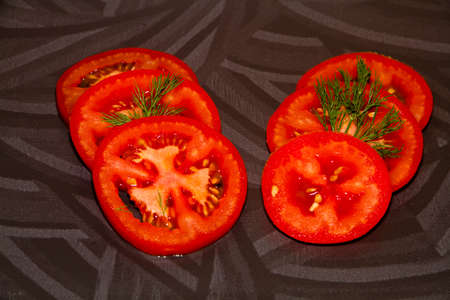 Fresh Sliced Red Tomatoes with Green Dill の写真素材