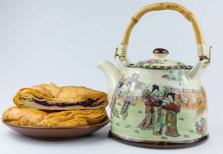 teapot and muffin on a plateの写真素材