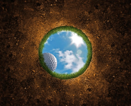 Golf ball falling over the edge into the holeの写真素材