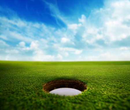Golf cup on a green on a sunny day.の写真素材