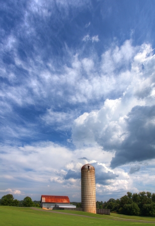 Old barn and silo under beautiful cloudy skies.の写真素材