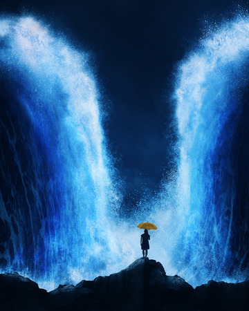A woman stands with an umbrella before an splitting ocean.の写真素材