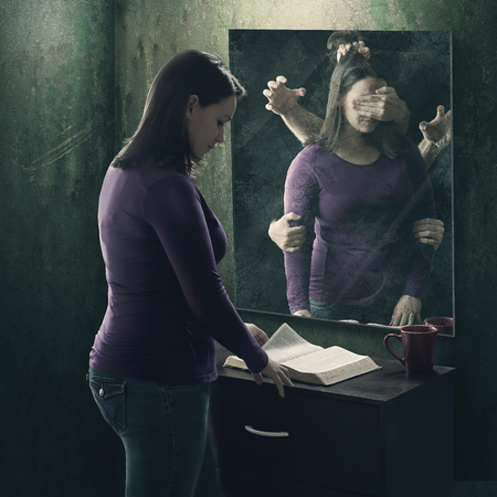 A woman reads her Bible as demons try to stop her
