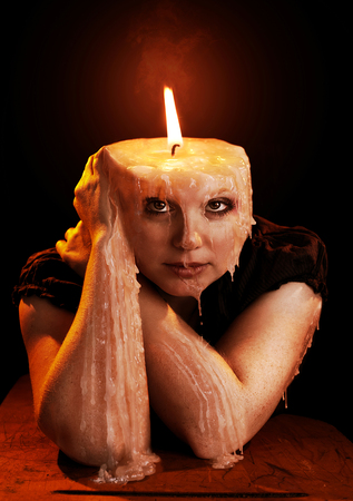 A woman in the shape of a candle is melting away.の写真素材