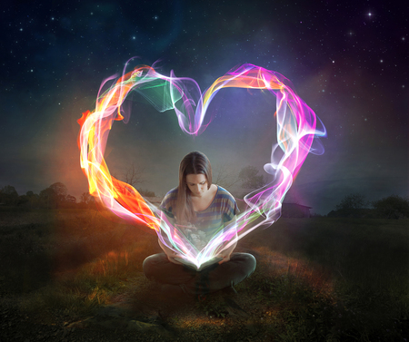 Glowing heart rays come out of a book.の写真素材