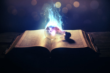 A light bulb on top of the Bible on fireの写真素材