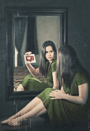 A woman looking into a mirror and wanting approval.の写真素材