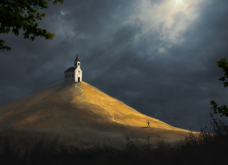 A small church rests on top of a large hillの写真素材
