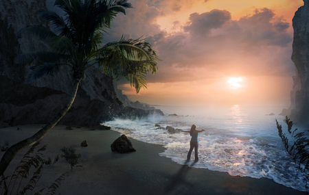 A woman lifts her arms on the beach at sunriseの写真素材