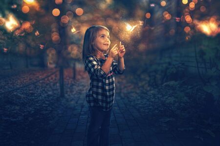 A little girl chasing glowing butterflies at night