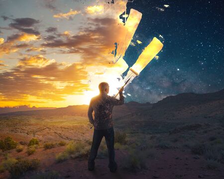 A man paints a beautiful sunrise over a night sky.