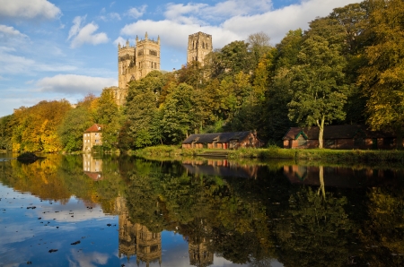 Durham Cathedral above the Old Fulling mill and boat houses reflected in the river wear in autumn colours の写真素材