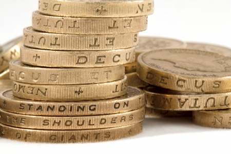 Stack of British one and two pound coins showing the quote  Standing on the shoulders of giants 