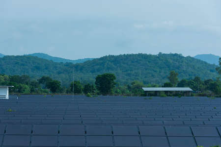 Man using a smartphone controlled  a solar panel with sky and mountains background Concept of...