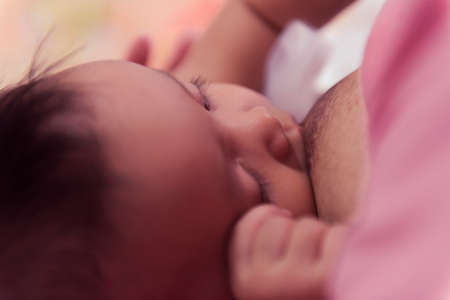 Baby eating breast milk. Mother breastfeeding her baby boy. Concept of lactation.