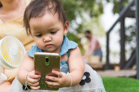 Little girl holding a cell phone, space for text messages, phone mount concept.