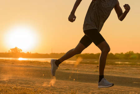 Runner feet running on road closeup on shoe. man fitness sunrise jog workout welness concept.の写真素材