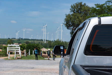 The car parked at the entrance to the windmill field,windmill field blurred background.