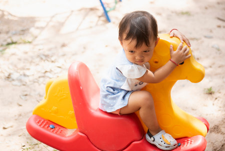 Picture of an Asian girl on an outdoor carousel.の写真素材
