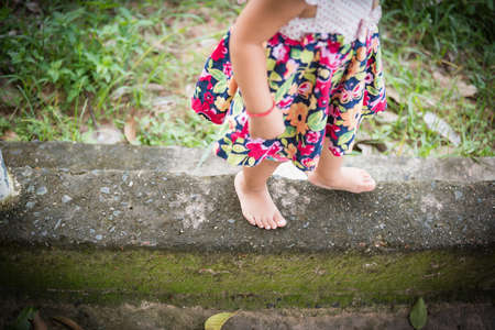 Young girl's feet walking on concrete . Focus on the spot.の写真素材