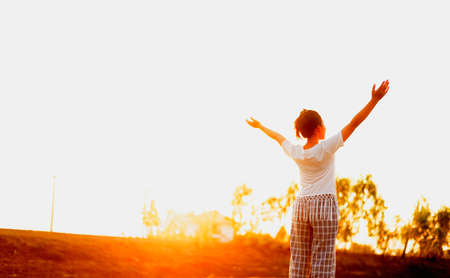 Silhouette side girl looking up Feel rejuvenated by the warm light and sky.の写真素材