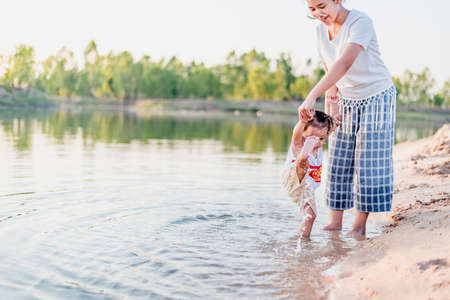 Mother and daughter walking on the beach.