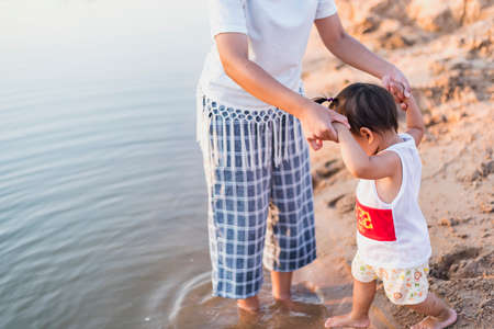 Mother and daughter walking on the beach.の写真素材