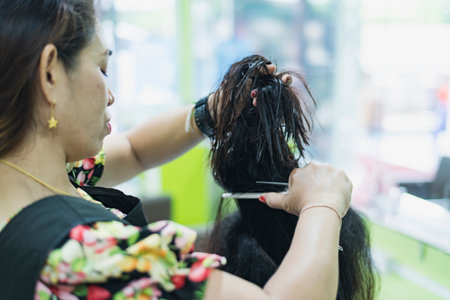 Hairdresser cutting hair of a woman in a beauty salonの写真素材