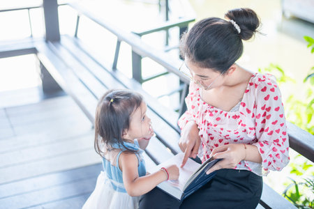 Asian mom with laptop working on desk from home along with raising a small child.の写真素材