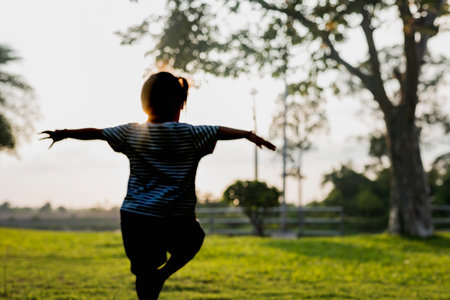 Silhouette,The girl stands and balances on one leg. in the backyard Family outdoor activities and relaxation concept.の写真素材