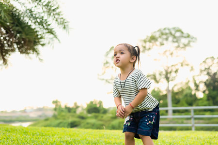 Happy children playing outdoors Boy jumping in a garden with sunlight summer vacation fun group of children playing in the playground healthy outdoor activities Sports for children.の写真素材