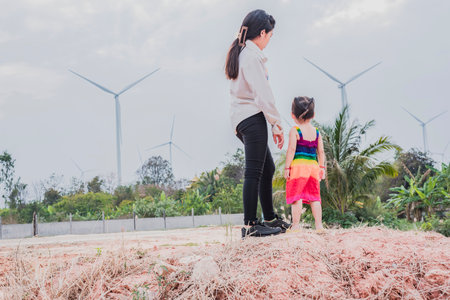 Asian girls study wind turbines to generate electricity. Sustainable energy. future.の写真素材