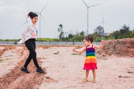 Asian girls study wind turbines to generate electricity. Sustainable energy. future.の写真素材