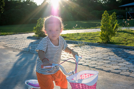 Cheerful happy young girl riding bicycle in park in nature, happy and having fun.の写真素材