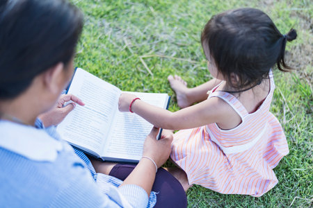 Girl with book on her head outdoors Female student portrait, education concept Happy cute kid...