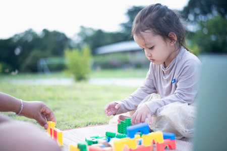 Daughter and mother playing with on the front yard. Concept of early learning and development.