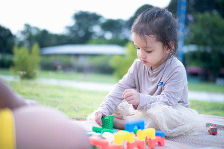 Daughter and mother playing with on the front yard. Concept of early learning and development.の写真素材
