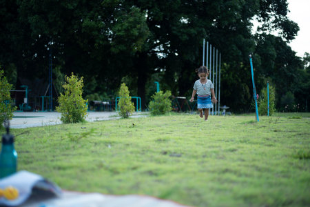 Girl running in the park Children's dream holiday concept, happy family. Running around in the sun.の写真素材