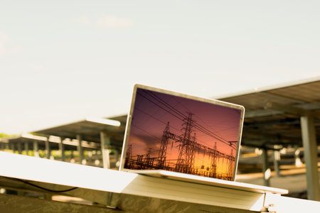 Engineer uses laptop computer to inspect solar panels, solar cell farm Concept of economic energy and cost savingの写真素材
