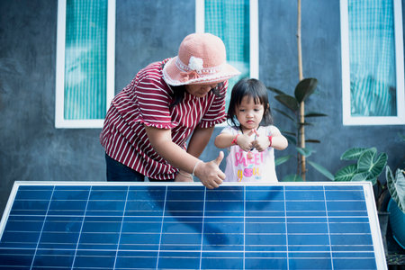 A happy Asian family admires the solar panels they just installed at their home.の写真素材