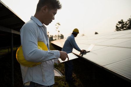 Electrical Engineer Technician Talk to business people to invest in install solar cells outside building or industrial factory. Collaboration on energy reduce for environment. Concept key workerの写真素材