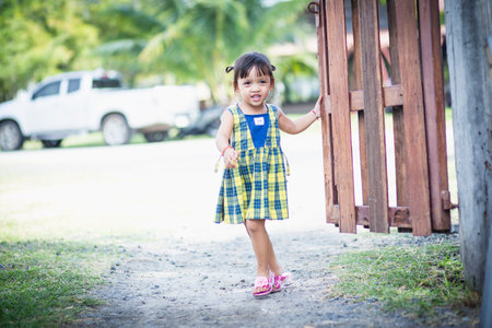 A girl opens the door to a flower garden and welcomes herself into beautiful nature.の写真素材