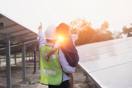 Mother and daughter on a solar farm filled with solar panels. Solar energy for future generations...