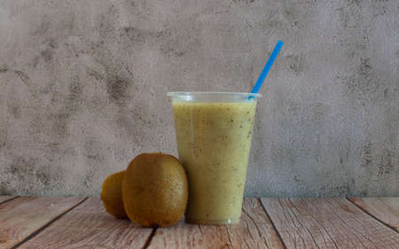 Fresh kiwi juice and a kiwi fruits on the table.の写真素材